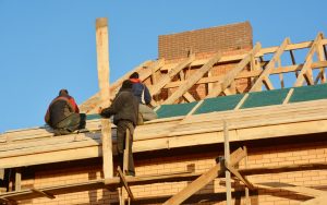 Roofing contractors installing wooden roof for house